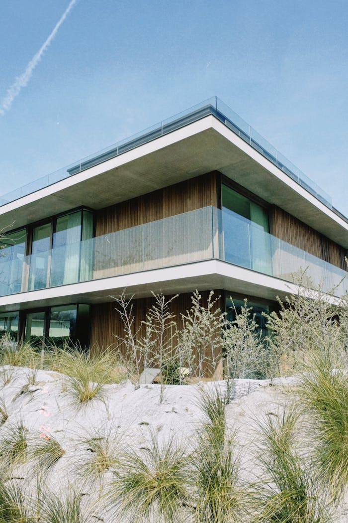 Contemporary villa featuring glass balconies and unique desert-inspired landscaping.