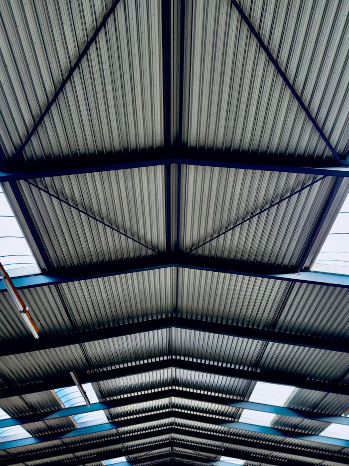 High-angle view of a modern industrial roof with corrugated steel and beams.